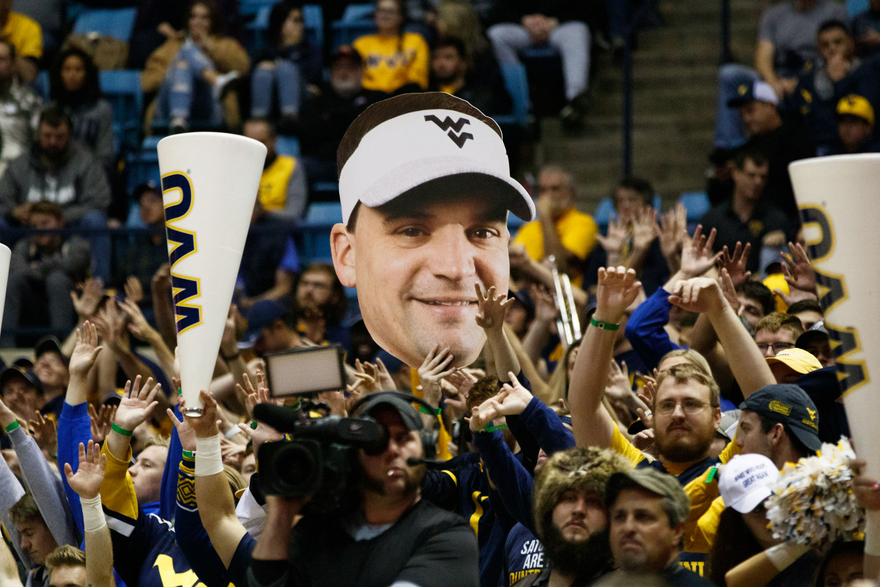 A fan holds a cutout of Neal Brown's face during West Virginia's season opener against Akron on Nov. 8, 2019 at the WVU Coliseum.